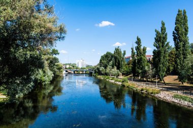 ORADEA, ROMANIA - 30 Temmuz 2021: Crisul Repede nehri, Dacia köprüsü ve Continental Forum Hotel ile Aydınlar Köprüsü 'nden (podul Paralelor sau entelektualilor) görüntü.