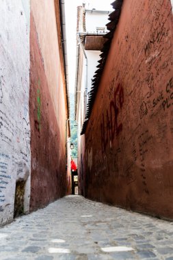 BRASOV, ROMANIA - 24 Eylül 2021: Rope Caddesi (Strada Sforii), Brasov 'un en dar sokaklarından biri ve Avrupa' nın üçüncü caddesi.