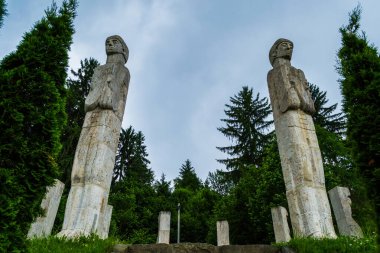 MOISEI, ROMANIA - 18 Haziran 2019: Ekim 1944 'te geri çekilen Horthist birlikler tarafından öldürülen Moisei şehitlerinin anısına anıt. Anıt 12 taş figür, 2 insan yüzü ve 10 geleneksel Denizcilik maskesinden oluşuyor..