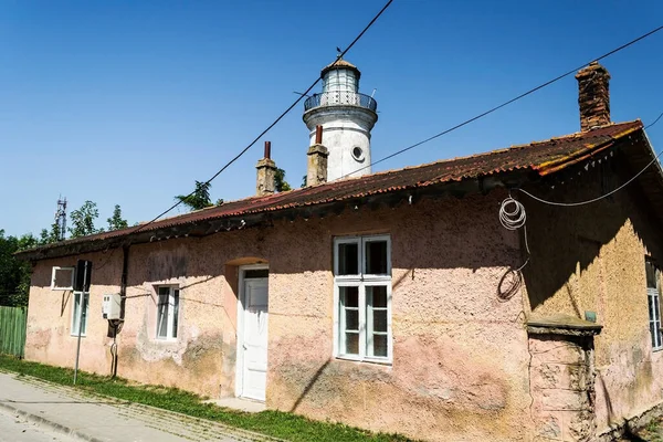 損傷した家と背中には古い灯台 サリナ ルーマニアです — ストック写真