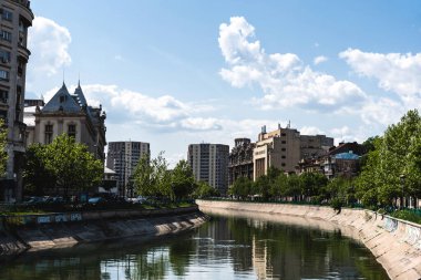 BUCHAREST, ROMANIA - 18 Mayıs 2022: Dambovita nehri ve önemli mimari yapılara sahip Splaiul Independentei Bulvarı manzarası.