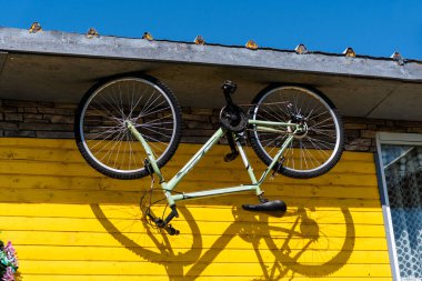 POLİENARI, GORJ, ROMANIA - benzersiz Romanya evini devirdi. Tepesinde asılı duran devrilmiş bisiklet..