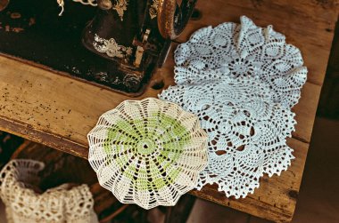 Masaya 90 derecelik açıyla el yapımı peçetelerle beyaz ipliklerle ateş etmek. Antika dikiş makinesi