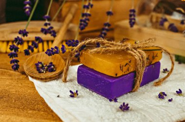 Masanın üzerine yerleştirilmiş bir fotoğraf. El yapımı sabun, kuru çiçekler, dekor. Kahverengi ahşap arka plan, boyalı cam işçiliği 