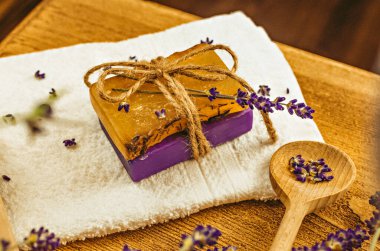 Masanın üzerine yerleştirilmiş bir fotoğraf. El yapımı sabun, kuru çiçekler, dekor. Kahverengi ahşap arka plan, boyalı cam işçiliği 