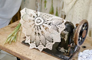 Masaya 90 derecelik açıyla el yapımı peçetelerle beyaz ipliklerle ateş etmek. Antika dikiş makinesi