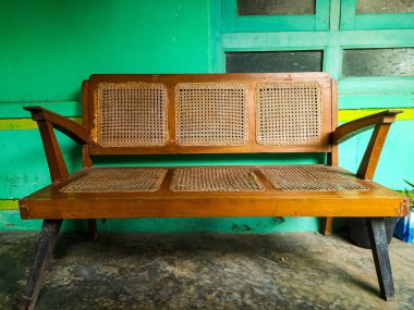 Bir terasta, eski kahverengi bir hasır sandalye..