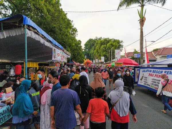 Blitar, Endonezya, 10 Nisan 2022, Ramazan pazarında, Blitar Meydanı önünde iftar menüsü almak için alışveriş yapan bir kalabalık..
