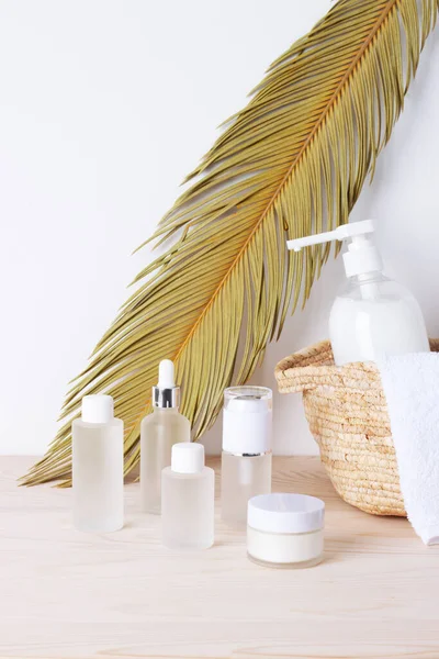 Spa treatment with natural skin care products, towel and basket on white background. Close up.