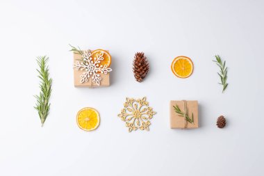 Beyaz arka planda biberiyeli el sanatları kağıdında çevre dostu hediyelerle Noel kompozisyonu. Sıfır Noel ziyanı konsepti. Düz yat, boşluğu kopyala