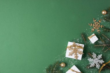 Paketlenmiş Noel süsleri ve yeşil arka planda Noel ağacı. Düz yat, boşluğu kopyala