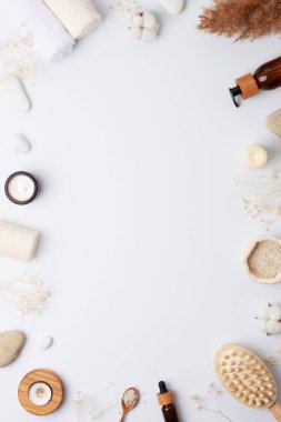 Doğal cilt bakım ürünleriyle spa tedavisi çiçekler, havlu ve beyaz arka planda yıkanma. Düz yat, boşluğu kopyala.