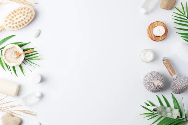 Spa treatment with natural skin care products, herbal bags, towel and wash on white background. Flat lay, copy space.