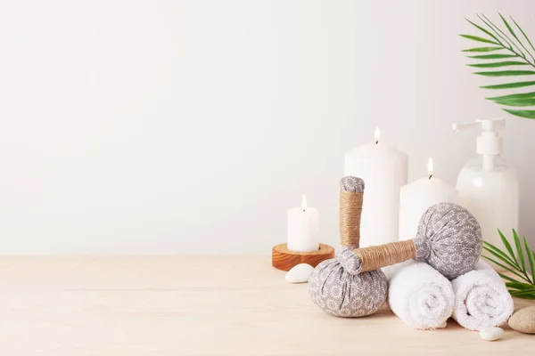 Spa treatment with herbal bags and candle on white background. Close up, copy space