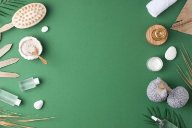 Doğal cilt bakım ürünleri, bitkisel çanta, havlu ve yeşil arka planda palmiye yaprağı ile kaplıca tedavisi. Düz yat, boşluğu kopyala.