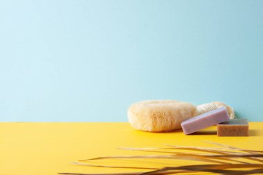 Mavi, sarı arka planda palmiye yaprağı olan fırça ve sabun. Kapat, boşluğu kopyala
