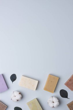 Gri arka planda sabun ve çiçek. Düz yat, boşluğu kopyala.