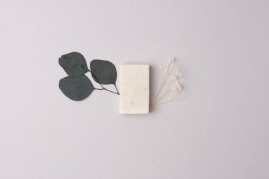 Gri arka planda çiçekli sabun. Düz yat, boşluğu kopyala.