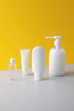 Sarı arka planda cilt bakım ürünleri olan kozmetik kompozisyonu. Kapat..