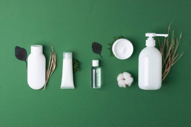 Kozmetik kompozisyon, kozmetik cilt bakım ürünleri ve yeşil arka planda çiçekler. Düz yat, boşluğu kopyala