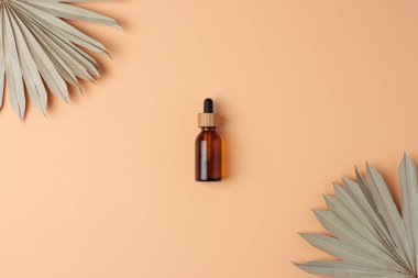 Bej arka planda tropikal kozmetik şişesi. Düz yatıyordu.