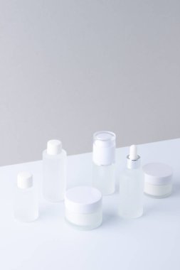 Gri ve beyaz arka planda cilt bakım ürünleri içeren kompozisyon. Kapat, boşluğu kopyala