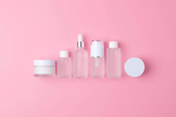 Skin care products on pink background. Flat lay, composition.