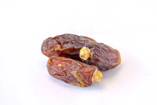 Bir yığın hurma, beyaz arka planda izole edilmiş lezzetli kuru tarihler. Arapça yemek.