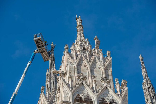 Milan Italy 1 December 2021: Technicians on lifting platform for scheduled maintenance plan and study of the degradation phenomena of the Milan cathedral