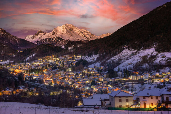 Snow-capped mountain village at the last light of day