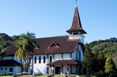 Arka planda mavi gökyüzü olan kilisenin önündeki mezarlık.