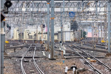 Tren rayları, boş tren istasyonundaki tellerin altından çaprazlama geçiyor.