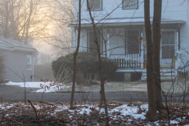 Sabahın erken saatlerinde sisi aydınlatan büyük karanlık ev. 