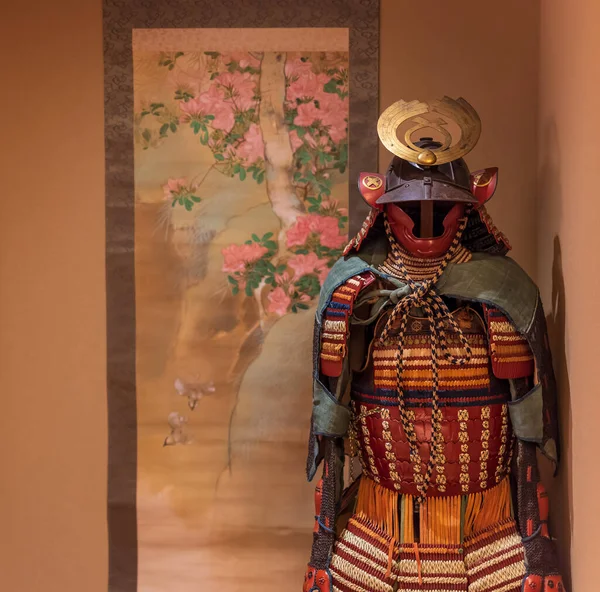 Бронекостюм самурая, стоящий рядом с японской картиной — стоковое фото