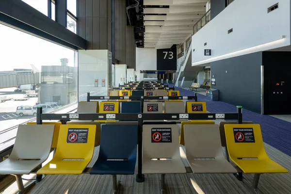 Señales de distancia social en la puerta de embarque vacía del aeropuerto en la terminal vacante — Foto de Stock