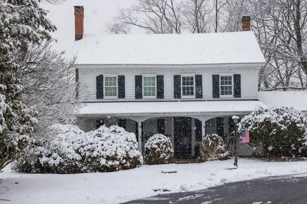 Karda küçük Amerikan bayrağıyla büyük bir ev 
