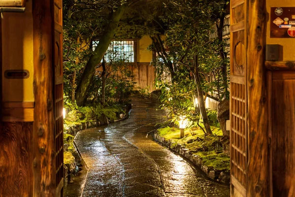 Tahta kapılar yağmurdan sonra Japon bahçesine açılıyor.