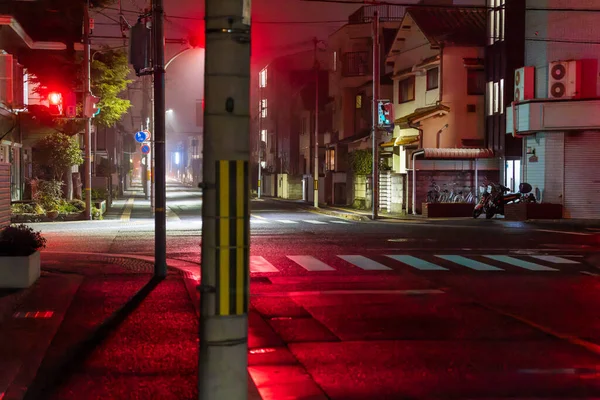 Röda trafikljus på tom korsning på natten efter regn — Stockfoto