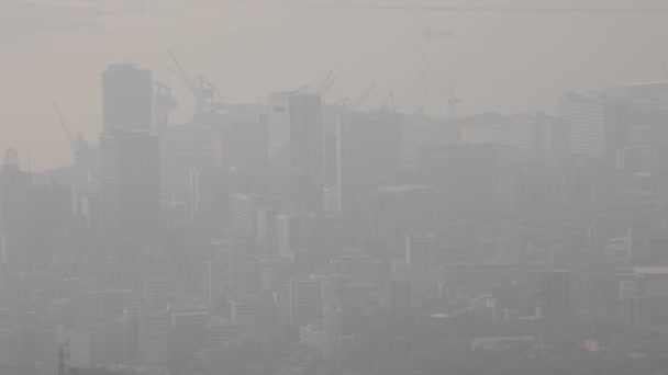 Langzame pan over bouwkranen en wolkenkrabbers in zware smog — Stockvideo