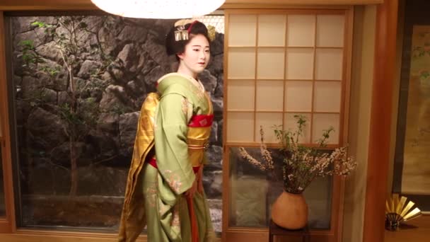 Kobe, Jepang - 26 Maret 2022: Maiko mengenakan kimono tradisional dan make up berjalan perlahan melalui kamar tradisional Jepang — Stok Video