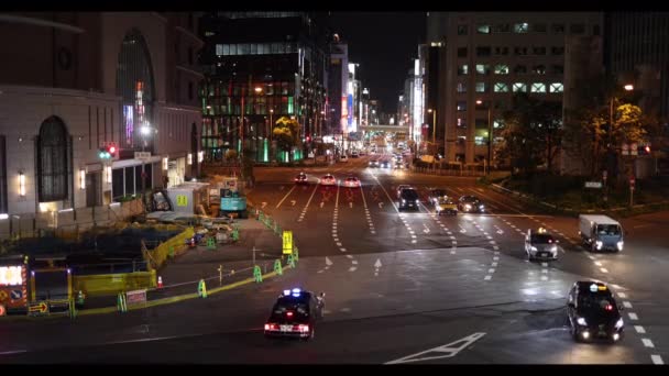 Osaka, Japan - May 1, 2022: Cars waiting and driving through intersection in central Osaka at night — Vídeos de Stock