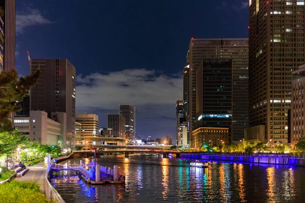 Colorful lights and office towers along river in city center at night — Stok fotoğraf