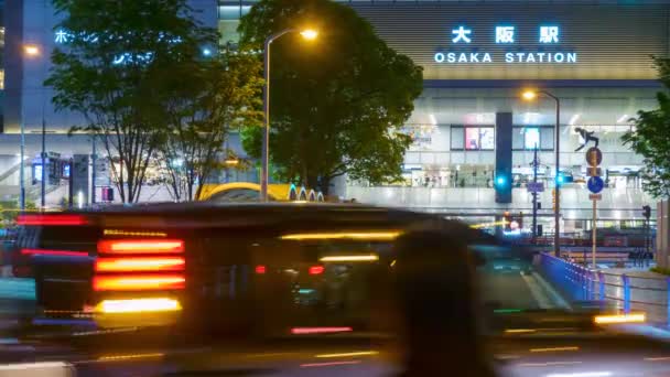 일본 오사카 - 2022 년 5 월 1 일: 밤에 JR 오사카 역 앞에 있는 자동차와 사람들의 시간 행렬 — 비디오