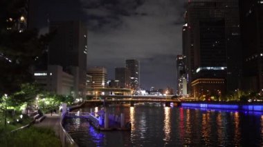 Slow pan over river in city center at night