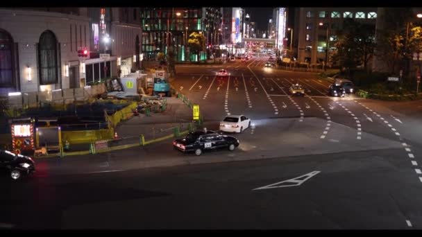 일본 오사카 - 2022 년 5 월 1 일: 일반적으로 밤에 우메다 역 옆에 있는 혼잡 한 교차로에서 가벼운 교통 — 비디오