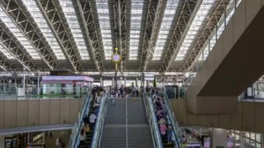 Osaka, Japan - May 12, 2022: People move up and down escalator as staff cleans stairs at JR Osaka Station