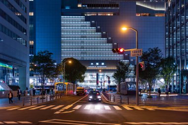 Osaka, Japonya - 1 Mayıs 2022: Taksi gece JR Osaka İstasyonu 'nun önündeki trafik ışıklarında bekliyor