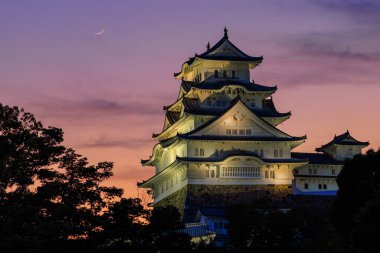 Himeji Kalesi üzerinde hilal ve günbatımı renkleri. Yüksek kalite fotoğraf
