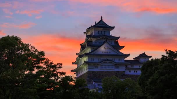 昼が夜になると 姫路城を象徴する色鮮やかな雲の時間の経過 月は夕暮れ時に始まる — ストック動画
