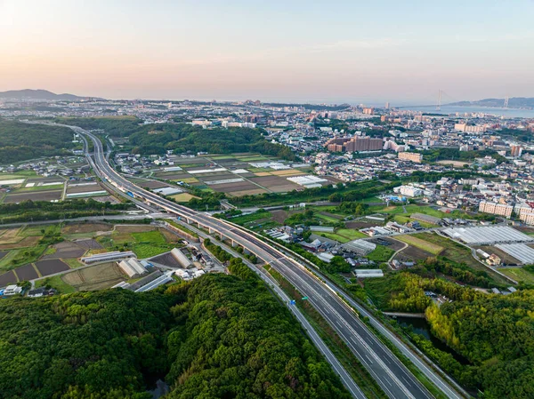 Widok Autostrady Przez Pola Ryżowe Zielone Wzgórza Rozległym Miastem Tle — Zdjęcie stockowe